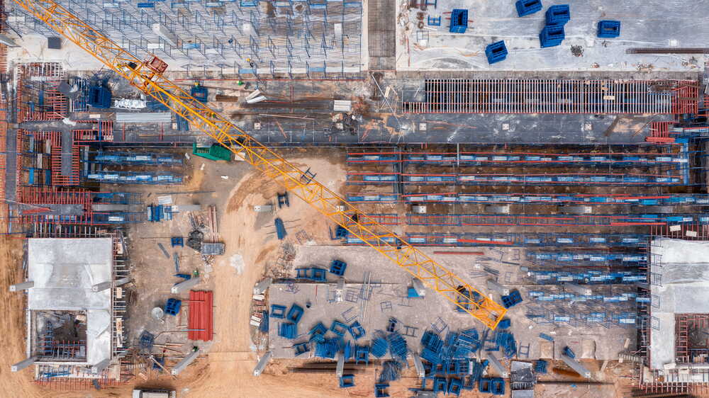 Aerial drone view of large UK construction site with rebar, formwork and crane
